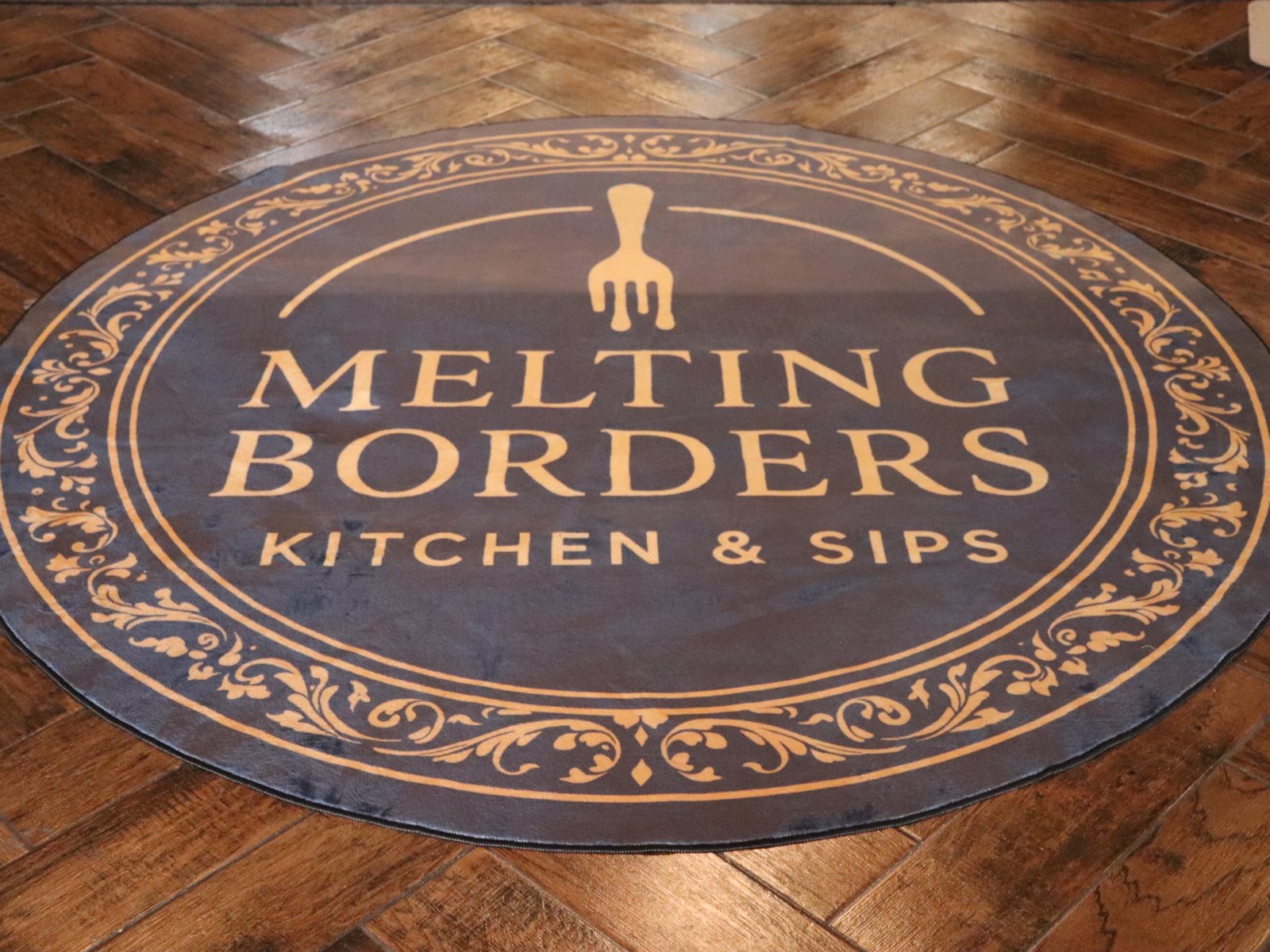 The Melting Borders logo rug at the entrance of the restaurant